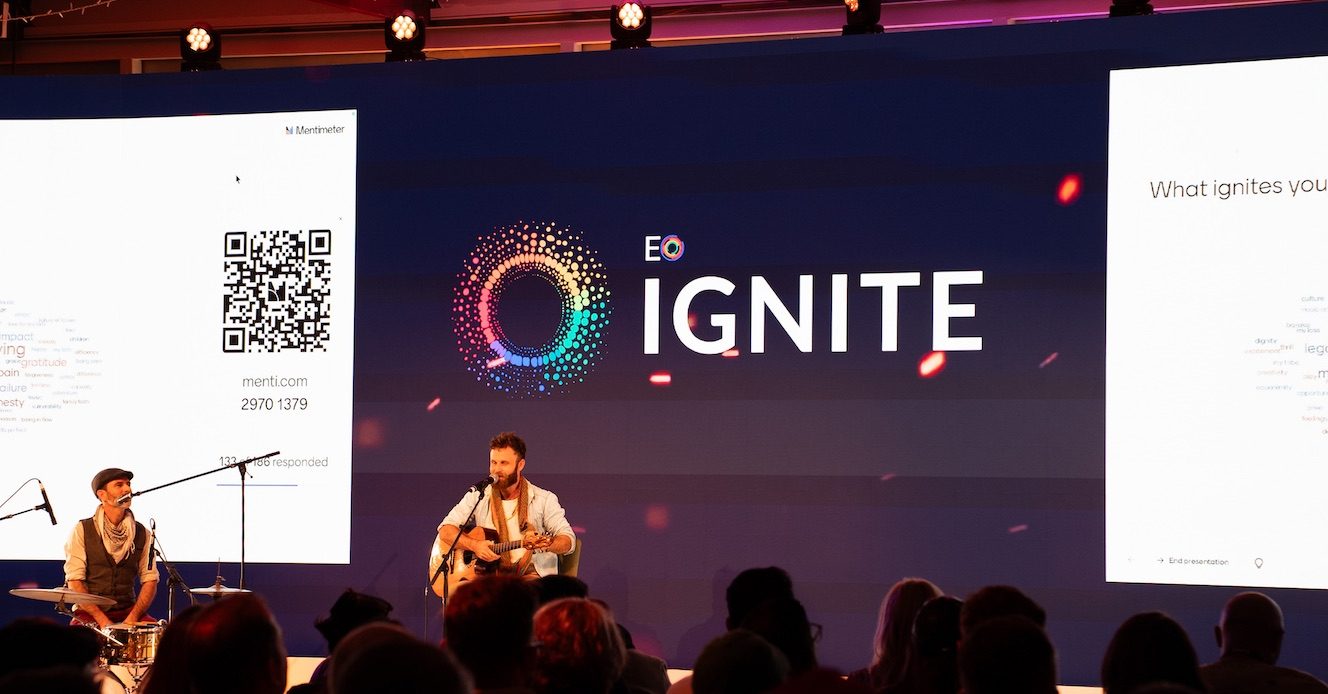 Nathan Maingard playing live at EO Ignite as the audience's own words appear in a word cloud on the screens